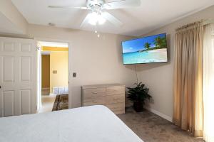 ポート・シャーロットにあるSerene Private Pool Home In Port Charlotteのベッドと壁にテレビが掛かった寝室 +40枚の写真