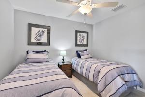 Breathtaking 3 BR condo with lake views in Lakewood National Golf Club - Shades Of Summer في برادنتون: غرفة نوم بها سريرين ومروحة سقف +27 صورة