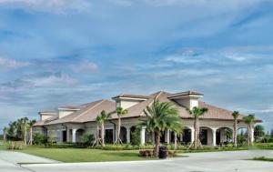 Breathtaking 3 BR condo with lake views in Lakewood National Golf Club - Shades Of Summer في برادنتون: منزل كبير أمامه أشجار نخيل