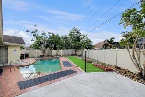 a backyard with a swimming pool and a fence at Private pool home with game room - Shaker Of Salt in Sarasota