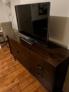 a flat screen tv sitting on top of a wooden dresser at Studio close to tower bridge in London