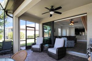 a screened in porch with chairs and a ceiling fan at Gorgeous lakefront home in Esplanade Golf & Country Club in Lakewood Ranch in Bradenton