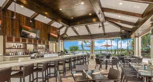 a restaurant with a bar with tables and chairs at Gorgeous lakefront home in Esplanade Golf & Country Club in Lakewood Ranch in Bradenton