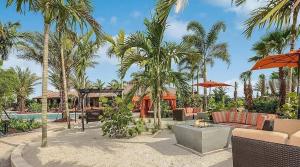 a resort with a swimming pool and palm trees at Gorgeous lakefront home in Esplanade Golf & Country Club in Lakewood Ranch in Bradenton