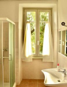 a bathroom with a sink and a window at Montino Coliving in Oggebbio