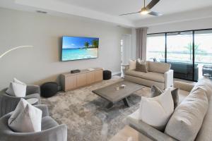 a living room with a couch and a tv on a wall at Luxurious pool home in Lorraine Lakes, Lakewood Ranch in Bradenton