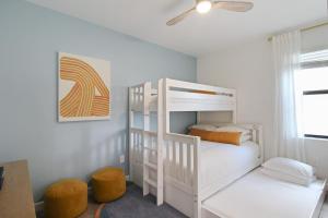 a white bedroom with a bunk bed and a ceiling fan at Luxurious pool home in Lorraine Lakes, Lakewood Ranch in Bradenton +70 photos