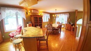 a kitchen and dining room with a table and chairs at Cottage with inground pool outside in Saint-Damien