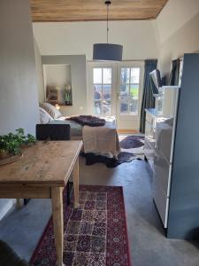 a living room with a table and a bed at Lodge bij Broer in Smilde +4 photos