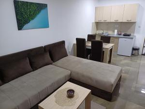 a living room with a couch and a table and a kitchen at Prenoćište SILVER LUX Srebrno Jezero 13 in Veliko Gradište