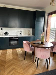 a kitchen with a table and chairs in a kitchen at Apartament 777 in Gdynia