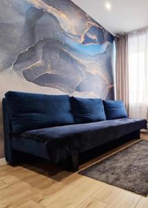 a black couch in a living room with a mural at Kielce City Center Paderewskiego 24 in Kielce
