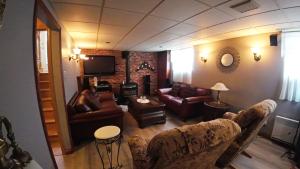 a living room with couches and a fireplace at Cottage with inground pool outside in Saint-Damien