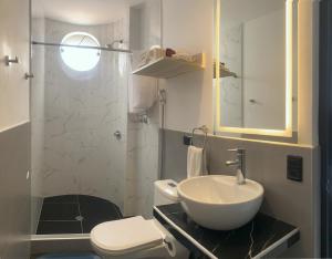 ein Badezimmer mit Waschbecken, Toilette und Spiegel in der Unterkunft Moderno Apto Estudio 01 in Cajamarca + 14 Fotos