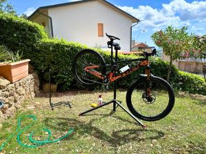 Una bicicleta en un puesto de bicicletas en el césped en Ferienwohnung Dolce Vita Toskana - Massa Marittima mit Parkplatz, Bikeferien meernah, en Massa Marittima