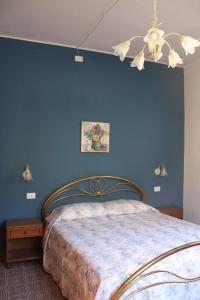 a blue bedroom with a bed and a chandelier at Casa vacanze Rosa in Barga