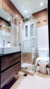 Un baño con ducha de cristal y un inodoro. en ROSE house, en Nydri