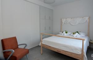 a bedroom with a bed and a chair at IRON House in Kavála