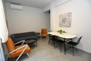 a living room with a couch and a table and chairs at IRON House in Kavála +12 photos