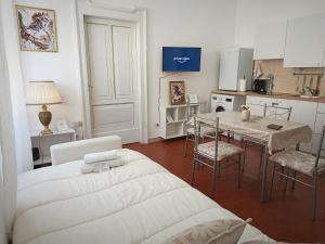 a living room with a bed and a table with chairs at Nobile Dimora - Centro Storico Ascoli Piceno in Ascoli Piceno