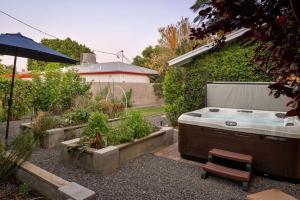 a hot tub in a garden with plants and an umbrella at Old Town Farm-to-Table Home - Gourmet Adventure with Pool in Scottsdale +46 photos