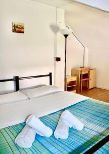 a bedroom with a bed with two towels on it at Montino Coliving in Oggebbio