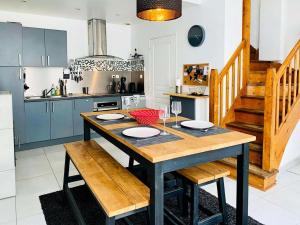 a kitchen with a wooden table in a kitchen with blue cabinets at Résidence B20-perros Guirec - Maison avec terrasse près du port de Perros-Guirec MAE-3764 in Perros-Guirec