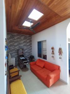 a living room with a red couch and a piano at CASA VACACIONAL FLANDES TOLIMA, GIRARDOT Conjunto PRIVADO in Flandes