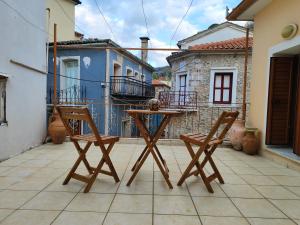 a table and two chairs on a patio with buildings at Agiasos House in Agiásos