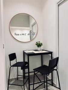 Un espejo en una habitación con dos sillas y una mesa. en La casa di Giorgia, en Catania