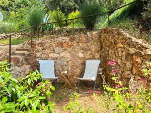 2 sillas y una mesa frente a una pared de piedra en Ferienwohnung Dolce Vita Toskana - Massa Marittima mit Parkplatz, Bikeferien meernah, en Massa Marittima 38 fotos más