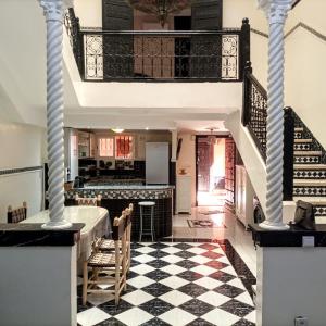 a living room with a staircase and a checkered floor at Riad Malika in Marrakech