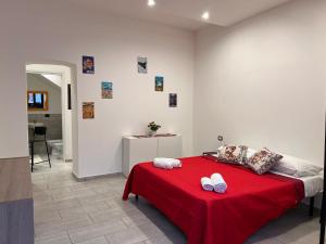Un dormitorio con una cama roja con una manta roja. en La casa di Giorgia, en Catania
