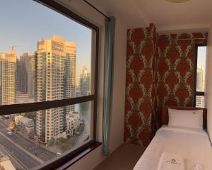 迪拜Horizon Rooms JBR的一间卧室，窗户可以欣赏城市景观