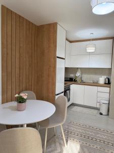 a small kitchen with a white table and chairs at Sanja apartman in Bar +5 photos