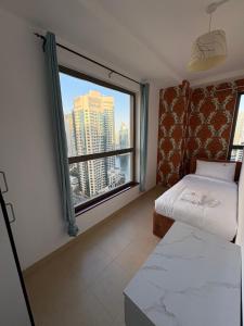 迪拜Horizon Rooms JBR的卧室设有大窗户,享有城市美景
