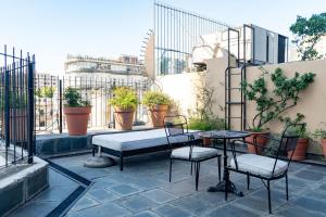 een terras met een tafel, stoelen en planten bij Bellinzona Boutique in Buenos Aires