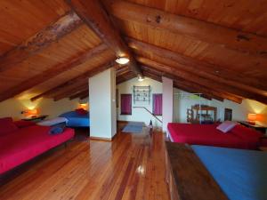 una sala de estar con sofás rojos y techos de madera. en La Ca dal Rino - Baita Panoramica Ecosostenibile, en Ornavasso