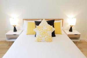 a bedroom with a white bed with two lamps at Aurelia Guest Suite and Sauna in Tofino