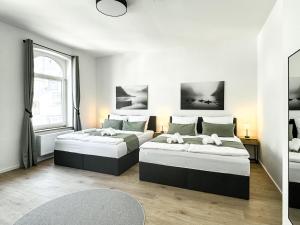 two beds in a white room with a window at Stobbe Stays I Zentral I Parkplatz I Kingsize I 116qm in Hannover