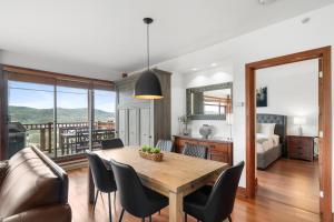 a dining room with a table and chairs and a bedroom at Tremblant Prestige - Altitude 172-8 in Mont-Tremblant
