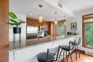 a kitchen with a counter with stools at Tremblant Prestige - Altitude 172-8 in Mont-Tremblant