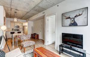 een woonkamer met open haard en tv bij Le CINQ in Montreal