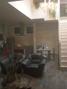ein Wohnzimmer mit einem Ledersofa und einem Tisch in der Unterkunft buon Talenti House in Florenz