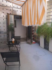 eine Terrasse mit einem Tisch, Stühlen und einem Sonnenschirm in der Unterkunft buon Talenti House in Florenz