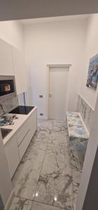a kitchen with a marble floor and a door at K&A Luxury Apartment in Anzio