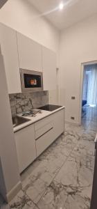 a kitchen with white cabinets and a stove top oven at K&A Luxury Apartment in Anzio