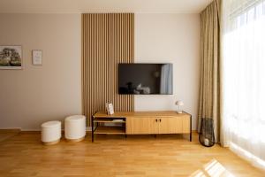 a living room with a flat screen tv on a wall at Wohlfühl-Maisonette mit Blick auf die Therme in Bad Saarow