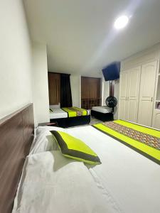 a bedroom with two beds with yellow and white sheets at Hotel Astorias in Pereira +3 photos