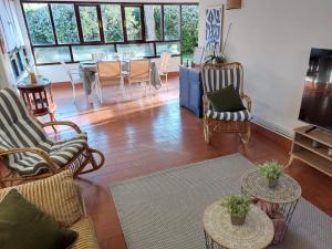 a living room with chairs and tables and a dining room at Vida Boa in El Dueso